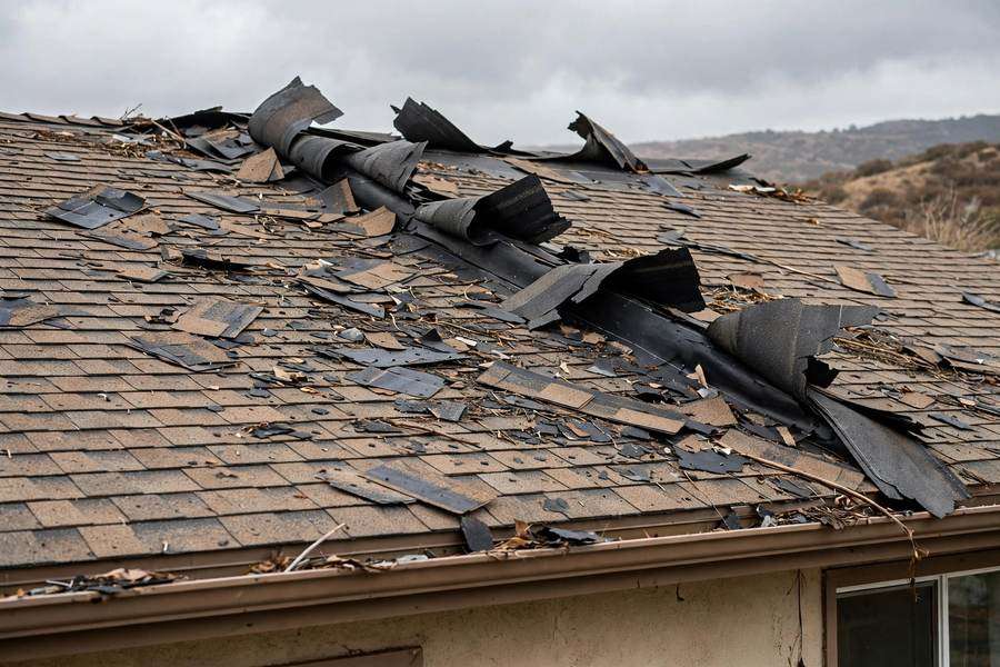 Wind-lifted ridge cap shingles after a Santa Ana wind event